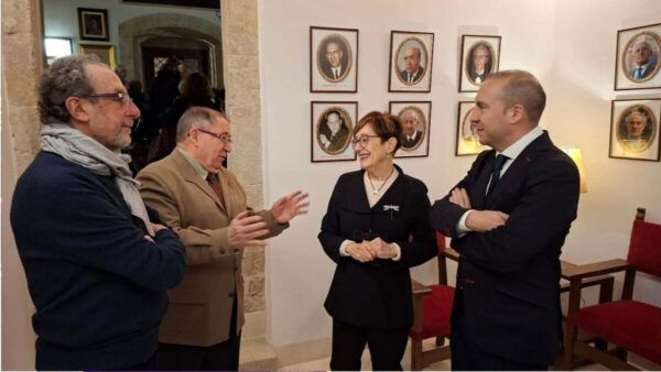 Celebración del 75º aniversario en la Torre del Clavero con asistentes conversando.