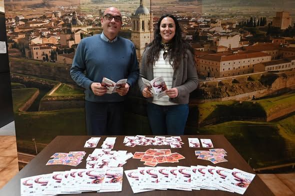 Dos personas sosteniendo programas del Carnaval del Toro 2026 en una mesa