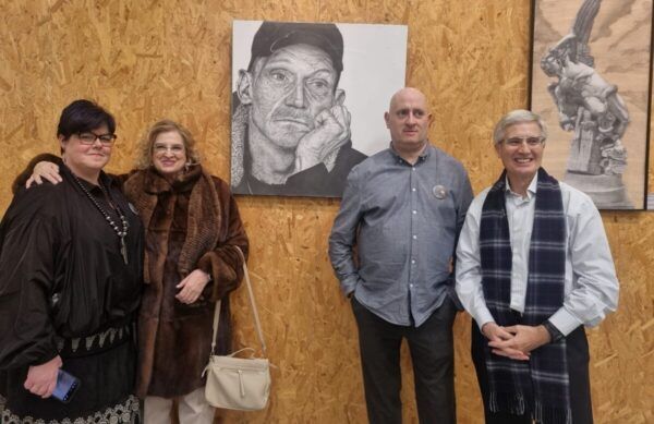David Sánchez y asistentes en la inauguración de su exposición de retratos.