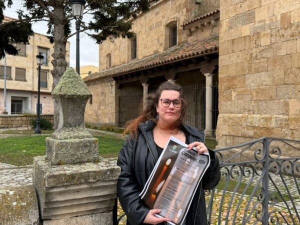 Mujer sosteniendo un cartel de Las Candelas en Villamayor