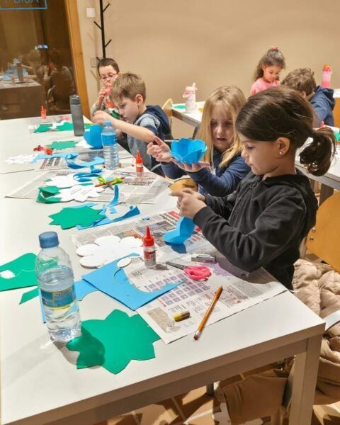 Niños realizando manualidades con papel de colores en Carbajosa.