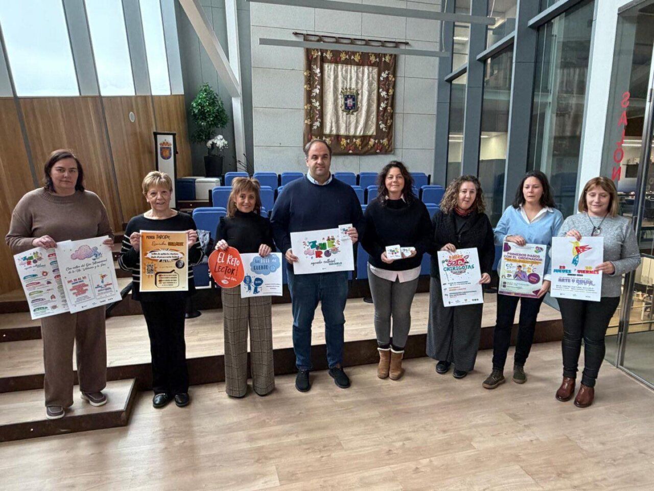 Grupo de personas sosteniendo carteles de actividades culturales en Guijuelo