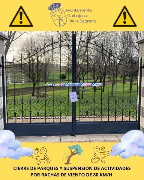 Puerta cerrada de un parque con aviso de cierre por fuertes vientos