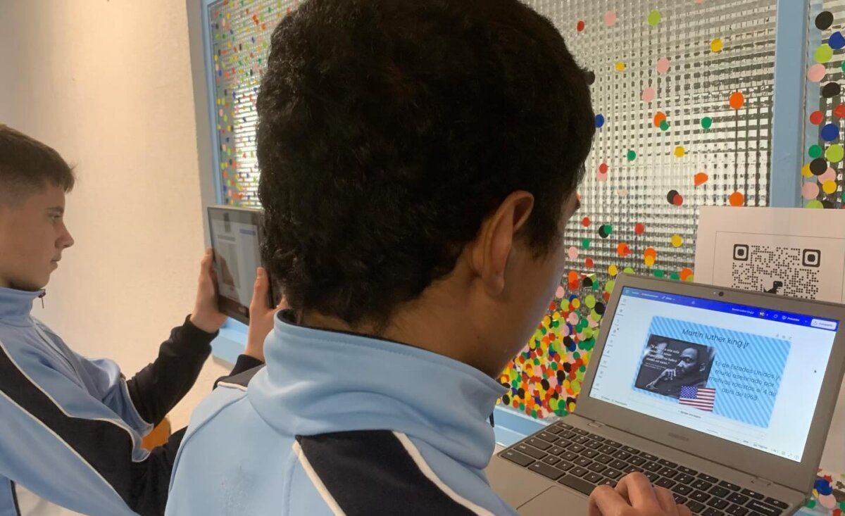 Estudiantes participando en el Día Escolar de la Paz con dispositivos electrónicos