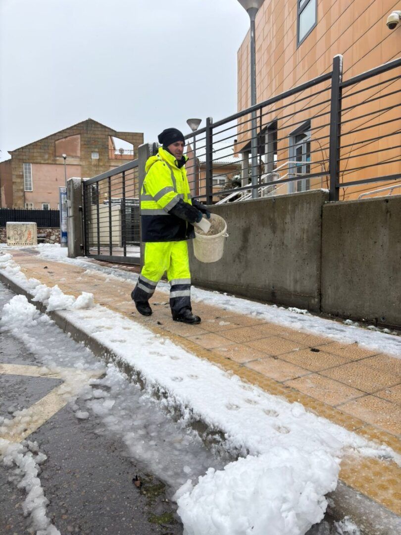 Trabajador del Ayuntamiento esparciendo sal en la calle durante nevada