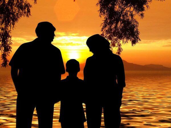 Silueta de una familia en la playa durante el atardecer
