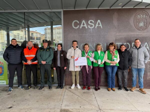 Grupo de personas en evento solidario en Guijuelo con cheque de donación