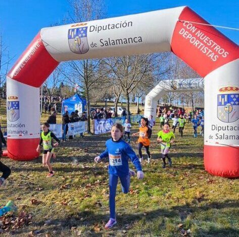 Jóvenes atletas corriendo bajo un arco de meta en Guijuelo