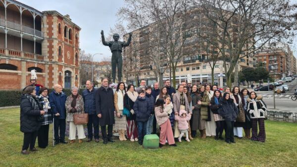 Grupo de personas rindiendo homenaje a Julio Robles junto a su estatua en Salamanca.