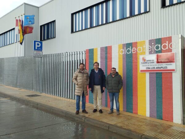 Tres hombres frente a un edificio colorido en Aldeatejada