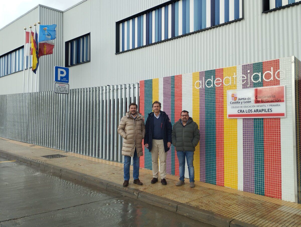 Tres hombres frente a un edificio colorido en Aldeatejada