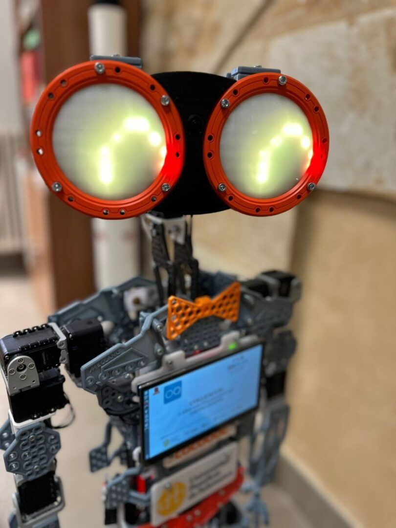 Robot Cocobot con luces y pantalla interactiva en un entorno educativo