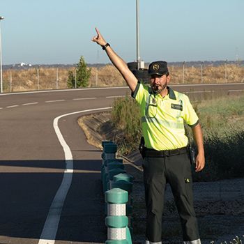 Agente de la Guardia Civil dirigiendo el tráfico con un gesto de mano.