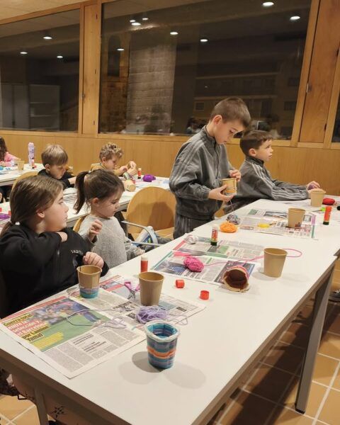 Niños creando portalápices en un taller de manualidades