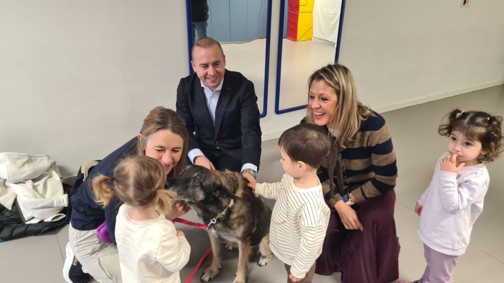 Niños interactuando con un perro en un taller escolar sobre mascotas