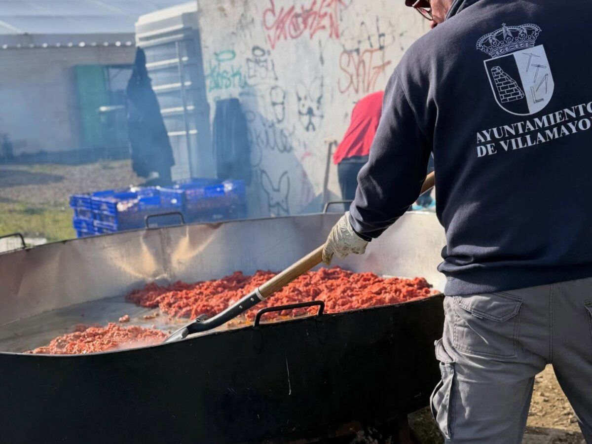 Persona cocinando en una gran olla durante una fiesta en Villamayor