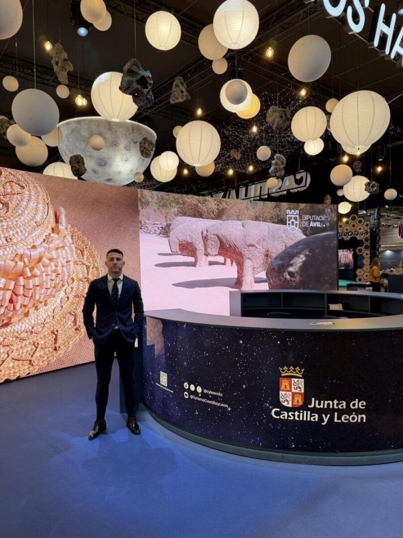 Hombre en traje junto a un stand de la Junta de Castilla y León