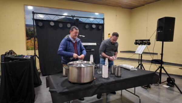 Dos hombres preparando alimentos en un evento de alborada en San Esteban de la Sierra