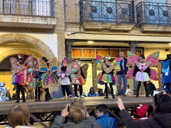 Niños en el escenario con disfraces coloridos de mariposas en el carnaval