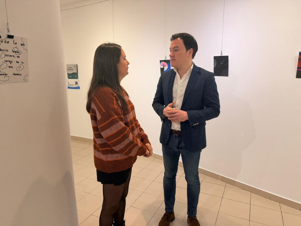 Dos personas conversando en una exposición de arte de Cruz Roja en Salamanca
