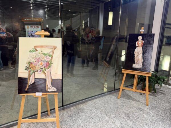Pinturas en exposición con flores y figura clásica en Guijuelo