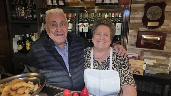 Pareja sonriente en el Café Bar Chinitas con decoración de San Valentín.