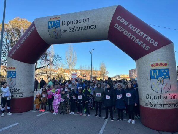 Participantes en la Milla Urbana de Peñaranda con un arco de meta