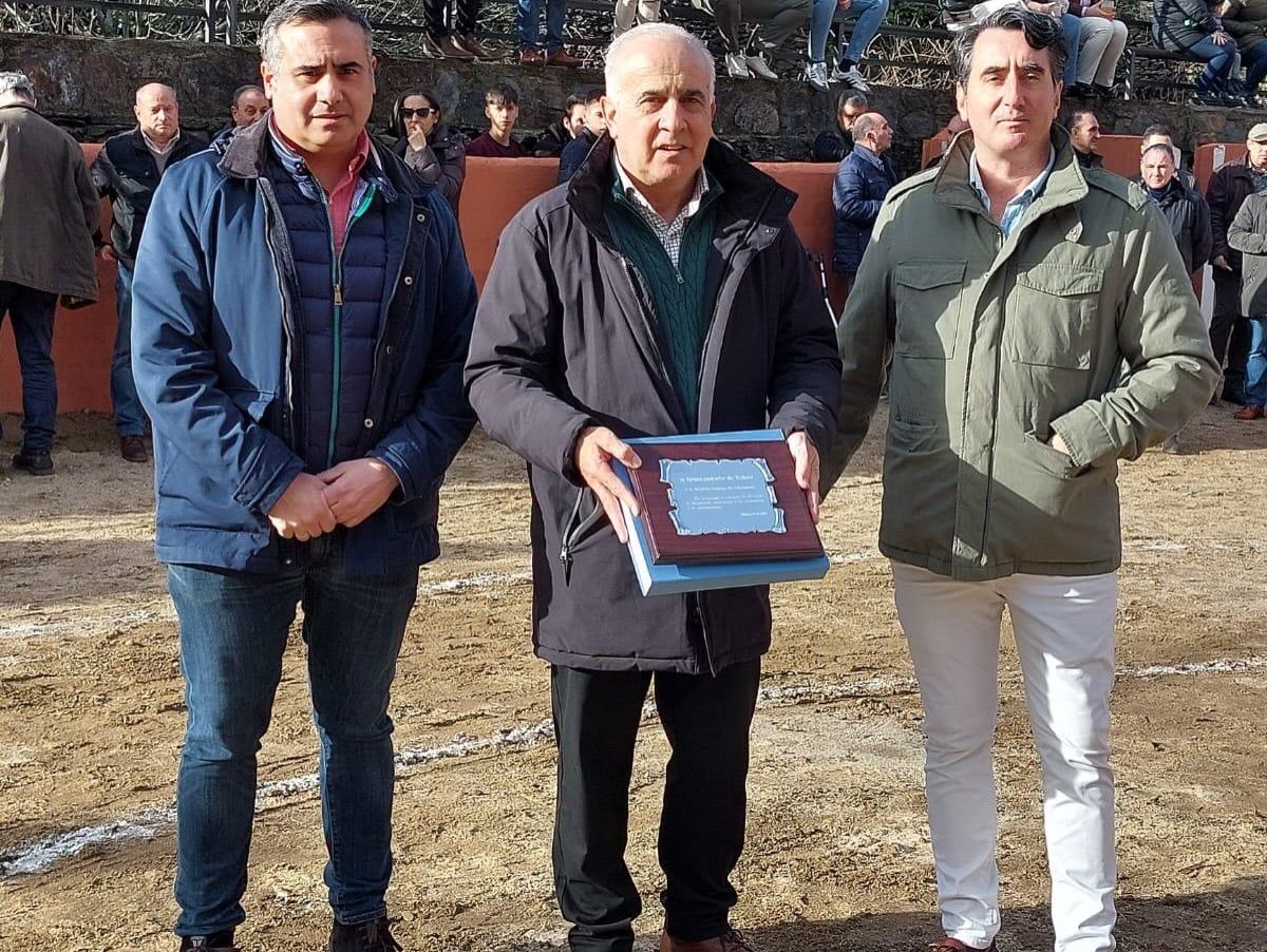 Tres hombres sosteniendo un reconocimiento en un evento taurino en Valero.