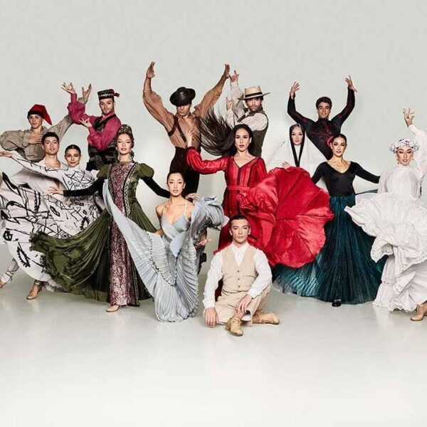 Grupo de bailarines en trajes coloridos realizando una coreografía