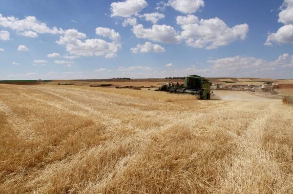 Campo de cultivo en Castilla y León con maquinaria agrícola trabajando