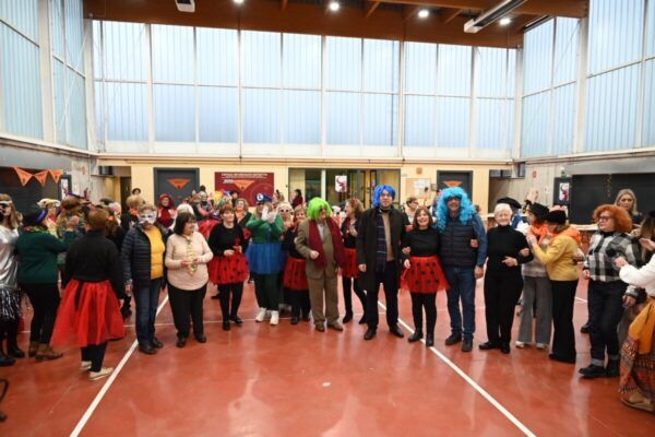 Participantes del Carnaval de la asociación Amanecer en Ciudad Rodrigo con disfraces coloridos.