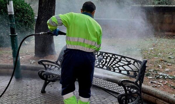 Trabajador limpiando un banco en el Ayuntamiento de Salamanca