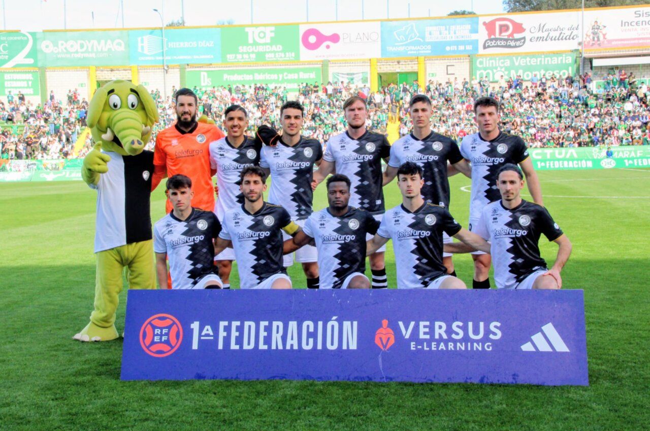Jugadores de Unionistas CF posando en el campo con un personaje disfrazado