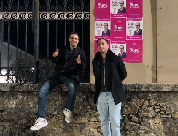 Dos hombres posando frente a carteles de UPL en Béjar