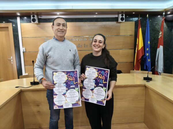 Dos personas sosteniendo carteles del Carnaval de Carbajosa de la Sagrada 2026