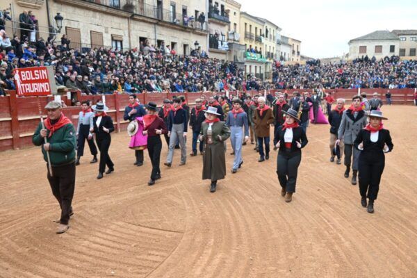 Desfile de participantes en el Carnaval del Toro en una plaza llena de espectadores