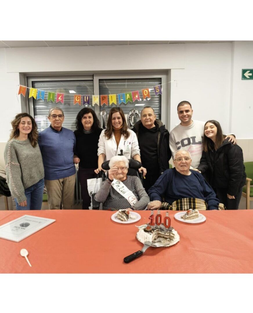 Grupo de personas celebrando el cumpleaños 100 de Francisca Romo con pastel.