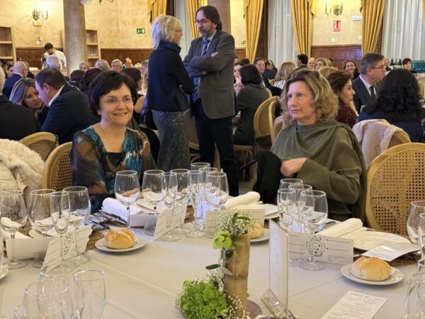 Dos mujeres sonrientes en una cena benéfica contra el cáncer en Salamanca.