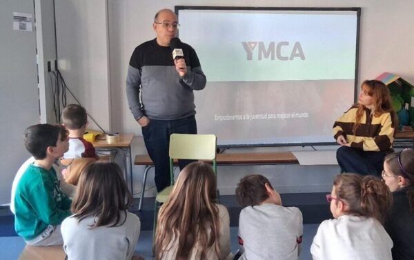 Niños escuchando a un ponente sobre voluntariado en una actividad