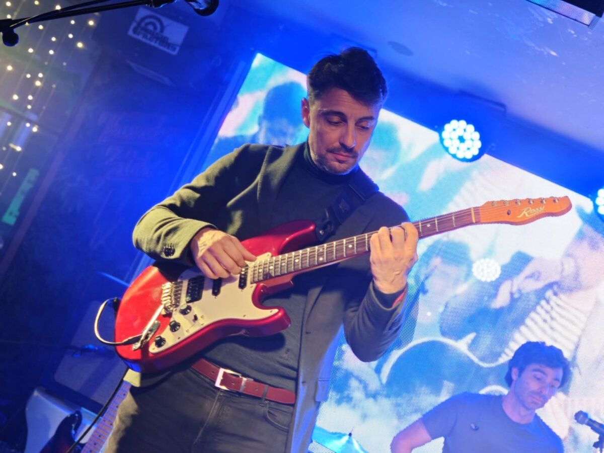 Músico tocando guitarra eléctrica en concierto homenaje a Joaquín Sabina