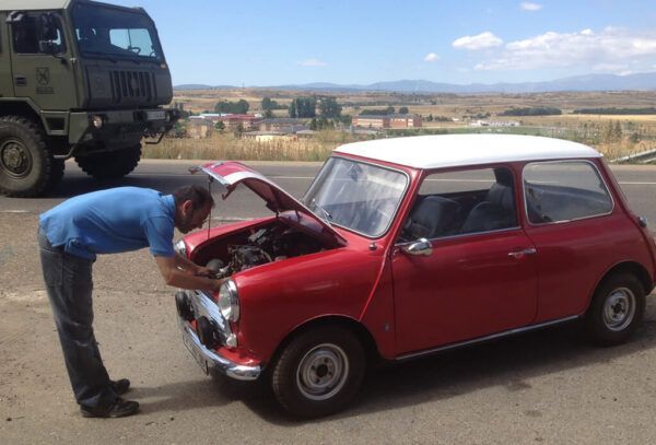 Hombre revisando el motor de un coche clásico en un laboratorio