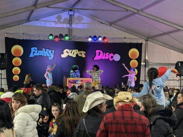 Espectáculo musical en la carpa del Carnaval de Guijuelo con niños y familias.