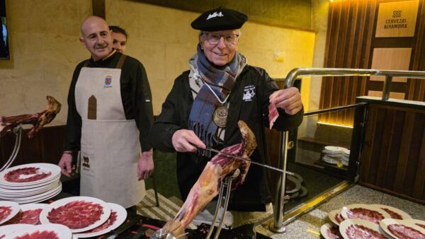 Participantes en la Matanza de Carnaval en Guijuelo cortando jamón ibérico.