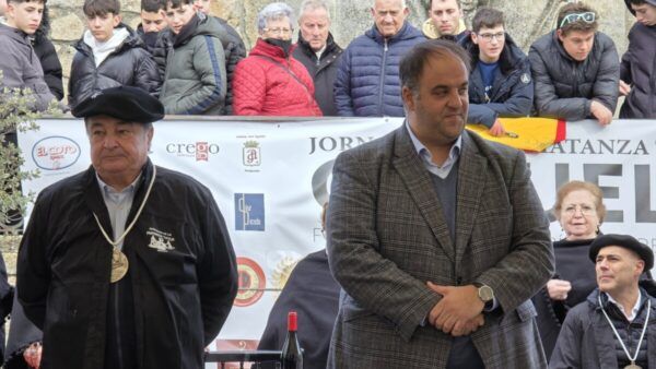 Dos hombres en la Matanza de Carnaval en Guijuelo con público al fondo