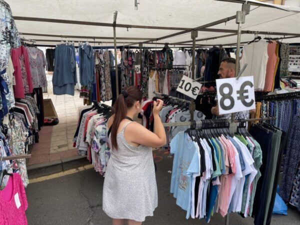 Puestos de ropa en el mercadillo de Guijuelo con precios visibles