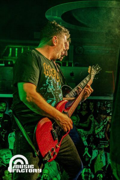 Músico tocando guitarra eléctrica en el concierto de Perros Verdes
