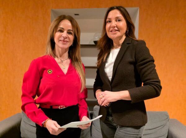 Dos mujeres posando en un entorno interior, preparándose para elecciones.