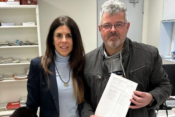 Chabela de la Torre y un hombre sosteniendo un documento en una oficina