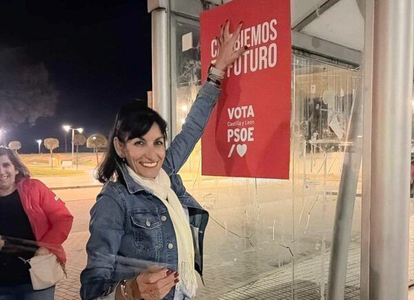 Miembro del PSOE de Salamanca colocando un cartel de campaña