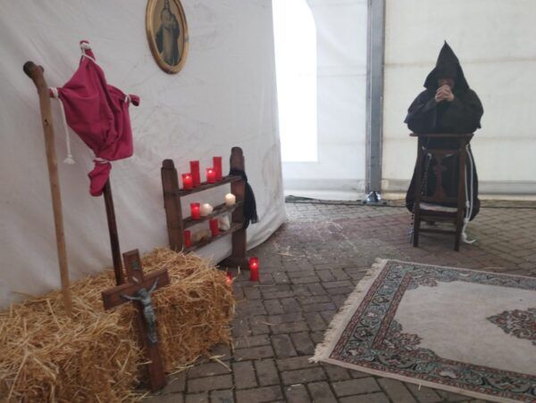 Escena de un campamento del siglo XVI con un monje y velas